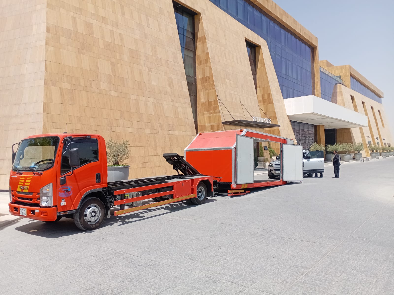 خدمة نقل احترافية - سطحة متخصصة أمام مبنى حديث